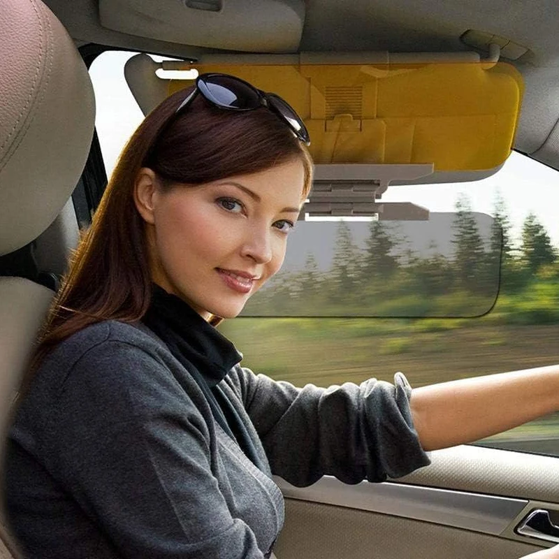 Driver seated in a car with the gray visor panel lowered and the yellow panel folded upward