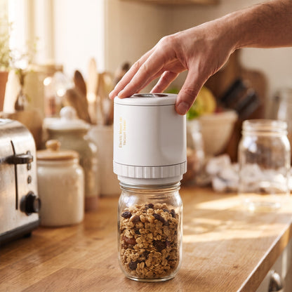 Pressing the sealer on a jar of granola